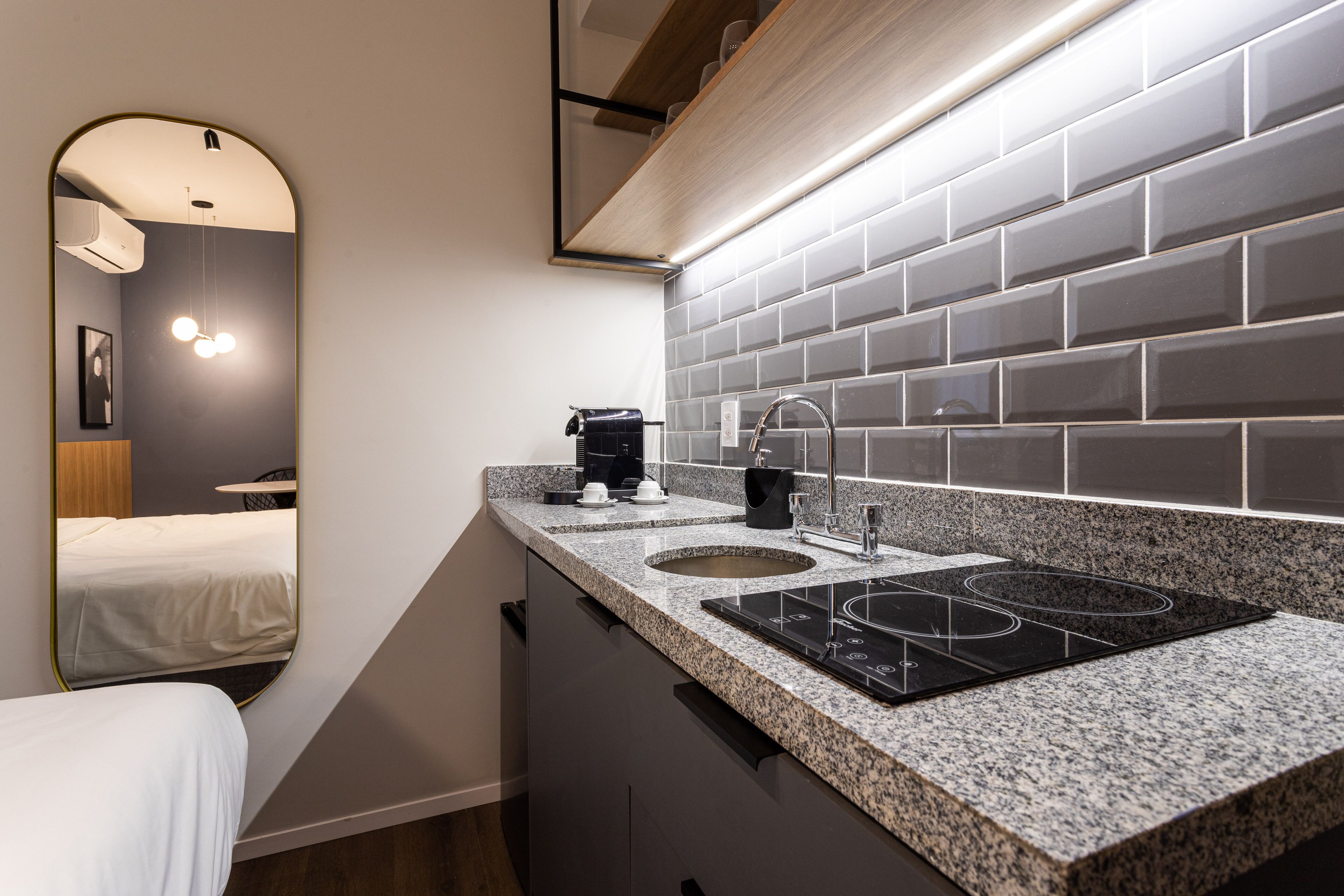 A modern bathroom with a sink, mirror, and a towel rack.