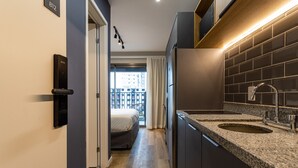 Un pasillo estrecho que da a un dormitorio con vistas a la ciudad.