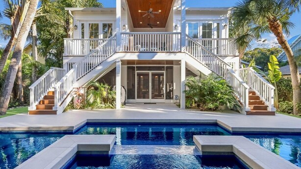 Una casa de dos pisos con piscina delantera.