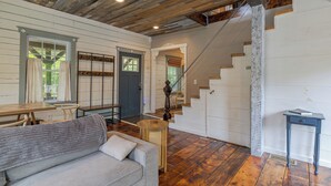 A spacious living area with a wooden ceiling, a staircase, and a dining area. - Old Maine style w/ modern amenities - dog friendly (Sullivan)
