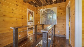 A wooden interior with a staircase, a hanging light fixture, and a large window. - Old Maine style w/ modern amenities - dog friendly (Sullivan)