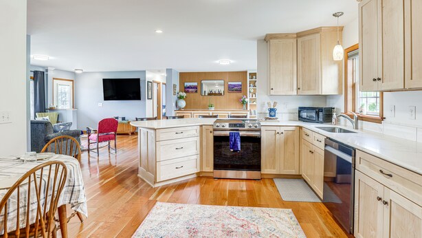 Una cocina moderna con armarios de madera, horno de acero inoxidable y microondas.