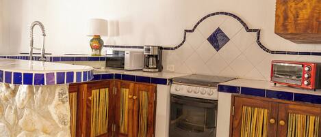 A kitchen with a stove, microwave, and toaster.
