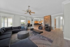 A spacious living area with a sofa, coffee table, and fireplace.