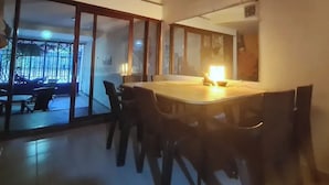 A dining area with a large table and chairs, a ceiling fan, and a view through large glass doors to an outdoor seating area. - Casa Inca Inca  (Santa Marta)