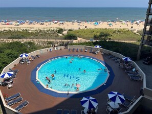 A pool area with a view of the beach, surrounded by lounge chairs and umbrellas. - High Point South 4C - 2 Bedroom Oceanfront condo, Oceanfront POOL (Ocean City)