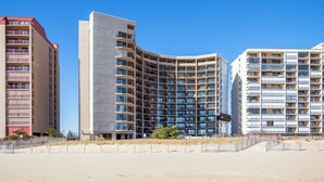 A modern hotel with multiple floors, balconies, and a curved facade.
