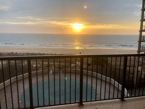 Ein Balkon mit Blick auf den Ozean bei Sonnenuntergang.