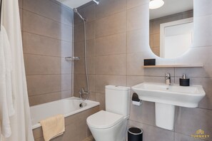 Une salle de bain moderne avec une baignoire, des toilettes et un lavabo.