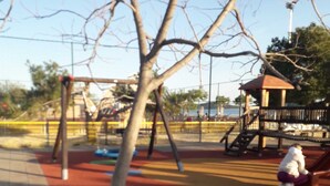 A playground with a slide, swings, and a climbing structure. - Beach apartment Srima (Vodice)