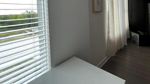 Ein Flur mit einer weißen Bank, einer gewebten Wanddekoration und einem gerahmten Bild an der Wand.