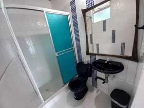 A bathroom with a shower, toilet, sink, and mirror. - Sede campestre PEÑA NEGRA (Tena)