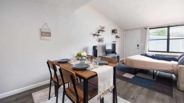 A compact living space with a dining area, a bed, and a TV. - Cozy den in Columbus (Columbus)