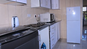 Una cocina moderna con microondas, estufa y refrigerador integrados.