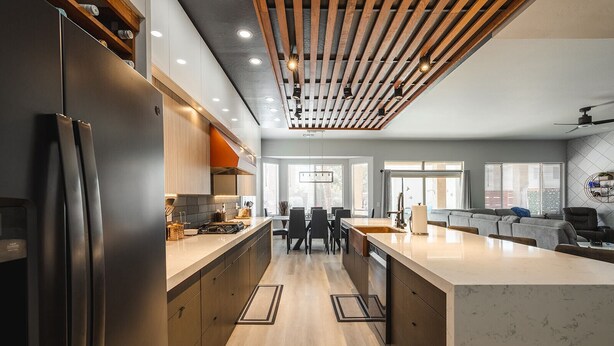 A modern kitchen with a central island, wooden ceiling beams, and a dining area with a view of the city. - Modern Luxury! Only 10 min. to AZ Athletic Grounds & A+ Dining Shopping! (Mesa)