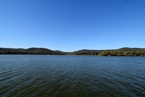 Un lac paisible, avec des collines boisées en arrière-plan.