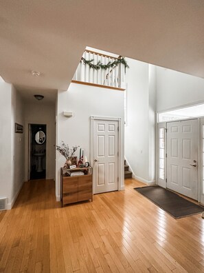 Stunning hallway with a staircase, console table, and mirror, set against a backdrop of modern architecture.