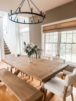 Enjoy meals in this dining area with a large table and comfortable chairs, surrounded by natural views.