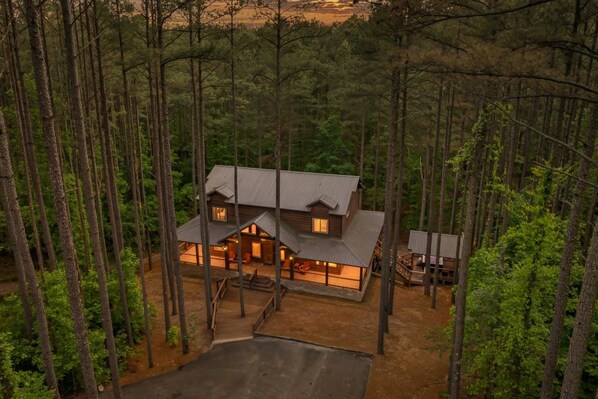 Aerial evening view of the cabin and driveway. - Low Rider Lodge backed up to Forest with ATV Trail Access from Driveway (Broken Bow)