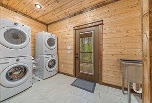 Laundry room with two stacked washer/dryer sets and utility sink. - Low Rider Lodge backed up to Forest with ATV Trail Access from Driveway (Broken Bow)