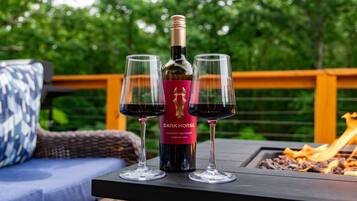 A bottle of Dark Horse Cabernet Sauvignon on a table with two glasses of wine, set outdoors with a wooden deck and greenery in the background.