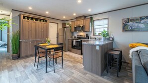 A modern kitchen with wooden cabinets, a central island, and built-in appliances. - Sky Lodge House - 3BR+BBQ - 5 min to BZN Airport (Belgrade)