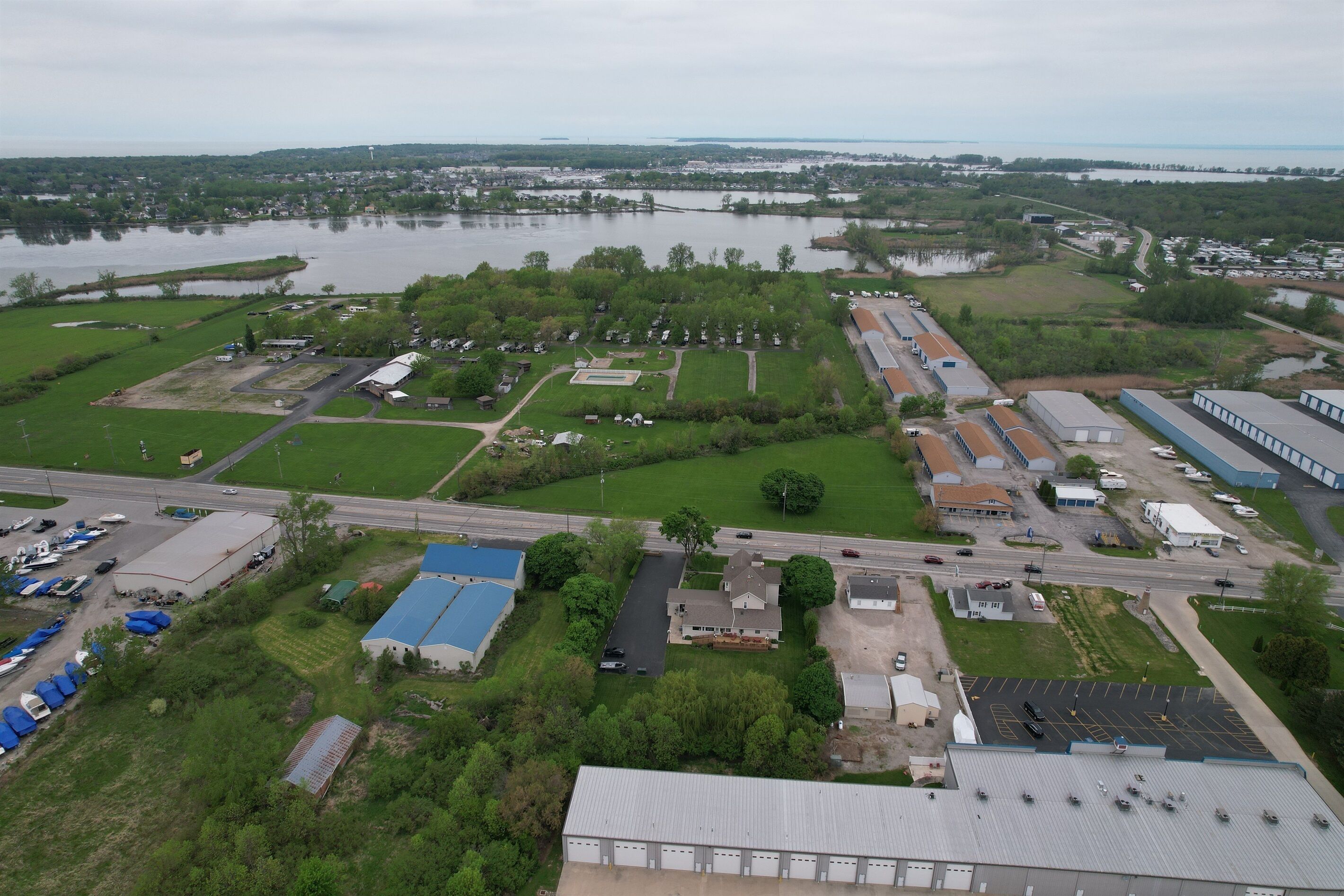 An industrial area with warehouses, a parking lot, and a large body of water.