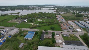 An industrial area with warehouses, a parking lot, and a large body of water.