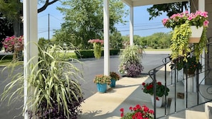 A covered outdoor area with potted plants and a staircase.