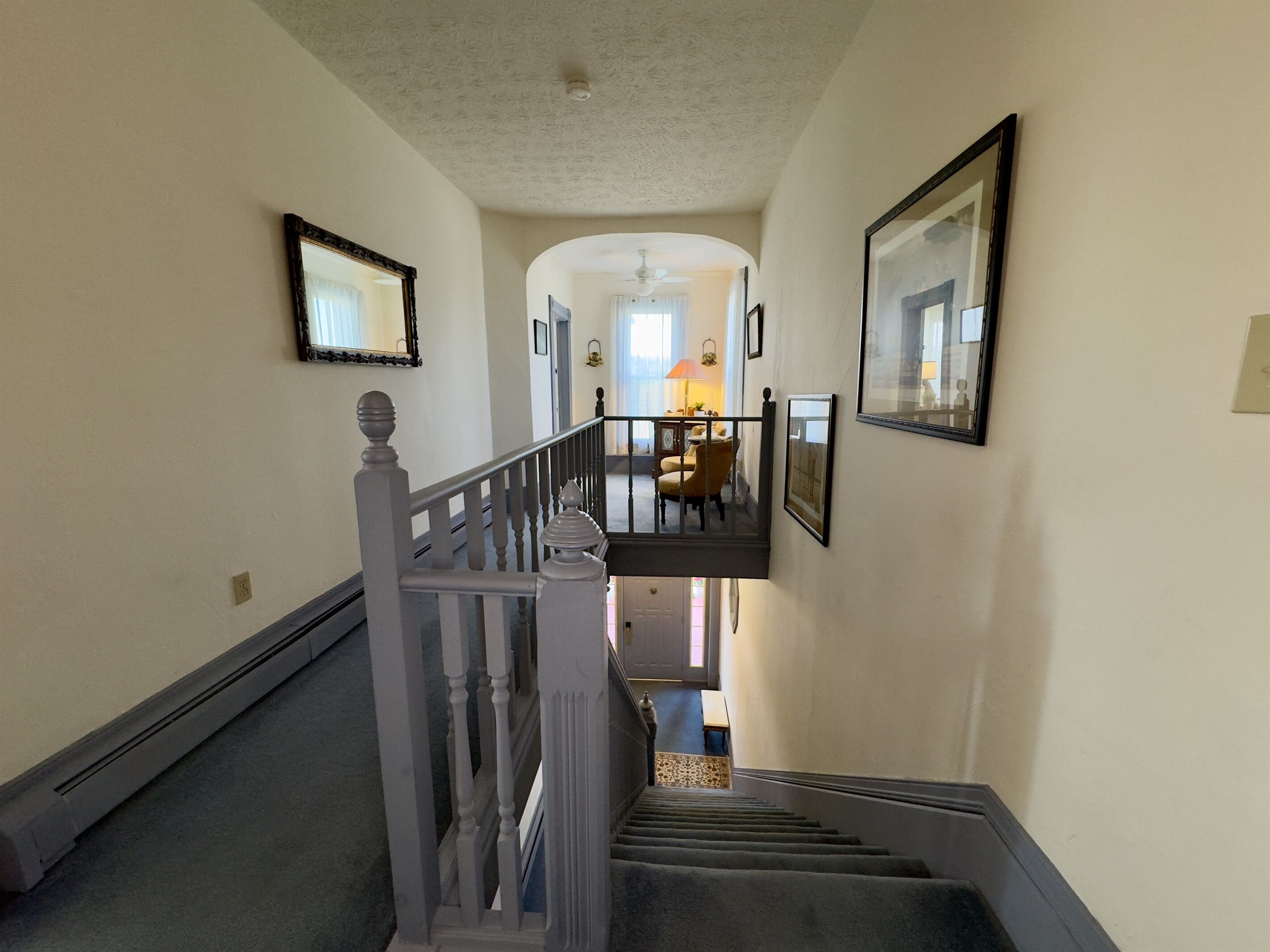 A staircase with a white railing leading to a second floor.