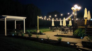 An outdoor patio area with string lights, umbrellas, and outdoor furniture. - Relaxing Couples Retreat Near Lake Erie (Lakeside-Marblehead)