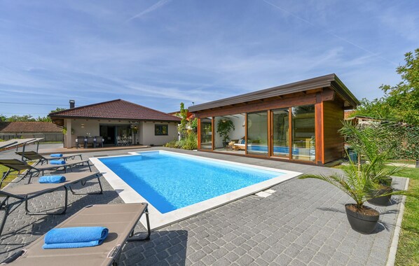 A modern house with a swimming pool, lounge chairs, and a patio area. - Amazing home in Puscine with sauna (Puscine)
