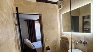 A compact bathroom with a shower, toilet, and sink. - Charming Apartment in Center Paris (Paris)