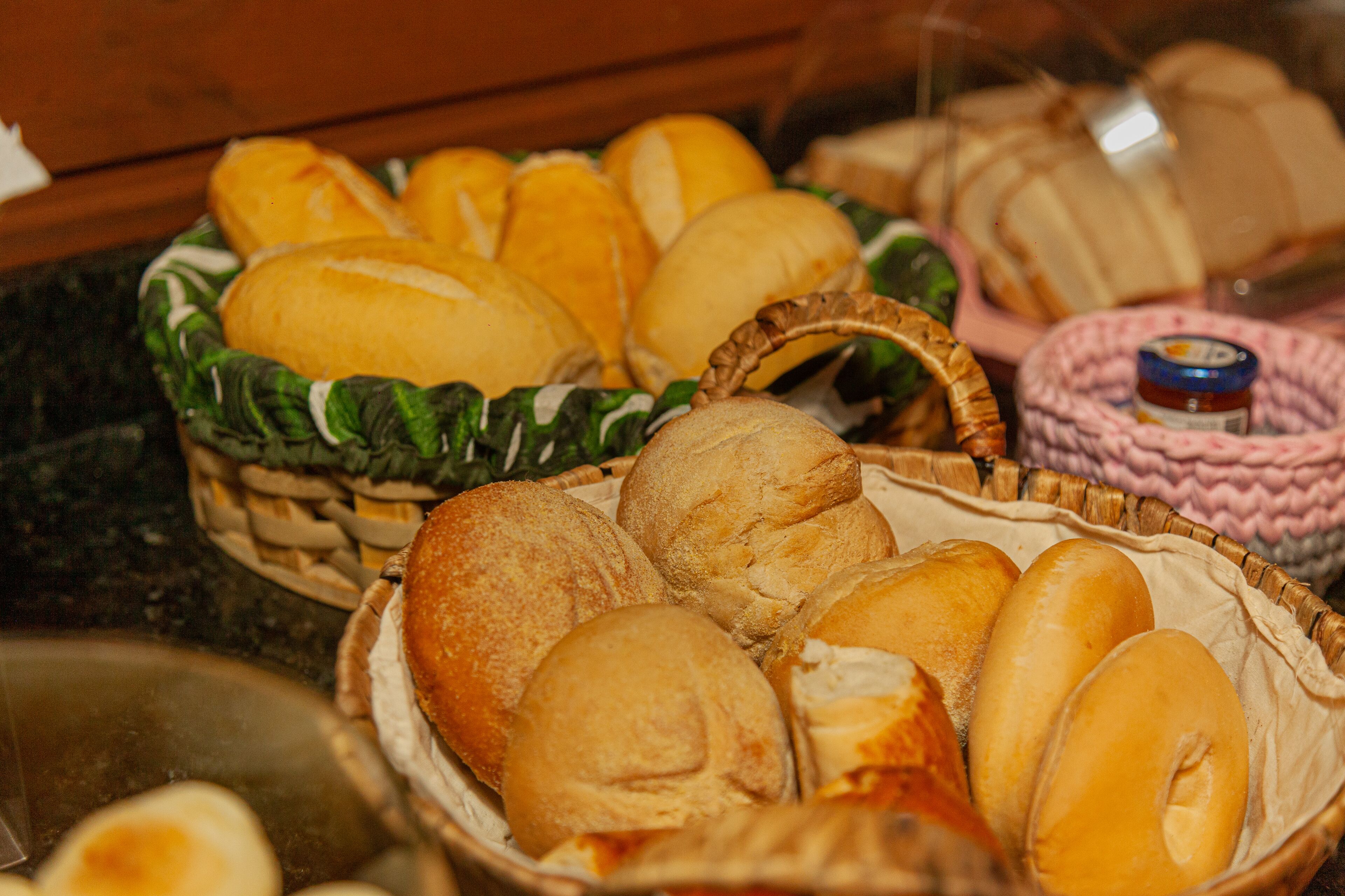 Diversidade de pães e doces em cestas.