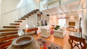 A spacious living area with a staircase, a fireplace, and a cozy seating arrangement.
