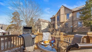 A deck with outdoor furniture, a grill, and a dining table with a plate of food and drinks. - Dog-Friendly 2BR Lodge, Pool by Big Cedar (Hollister)