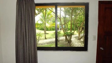 Una habitación con ventana que da a un jardín.