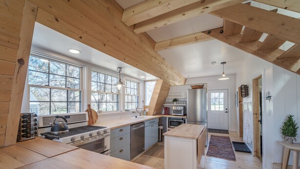 A spacious kitchen with wooden beams, large windows, and modern appliances. - The Cabin on Main St., A Quiet Getaway with whole family, History. Pet friendly. (Spring City)