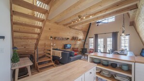 A cozy wooden interior with a loft bedroom, a dining area, and a kitchen. - The Cabin on Main St., A Quiet Getaway with whole family, History. Pet friendly. (Spring City)