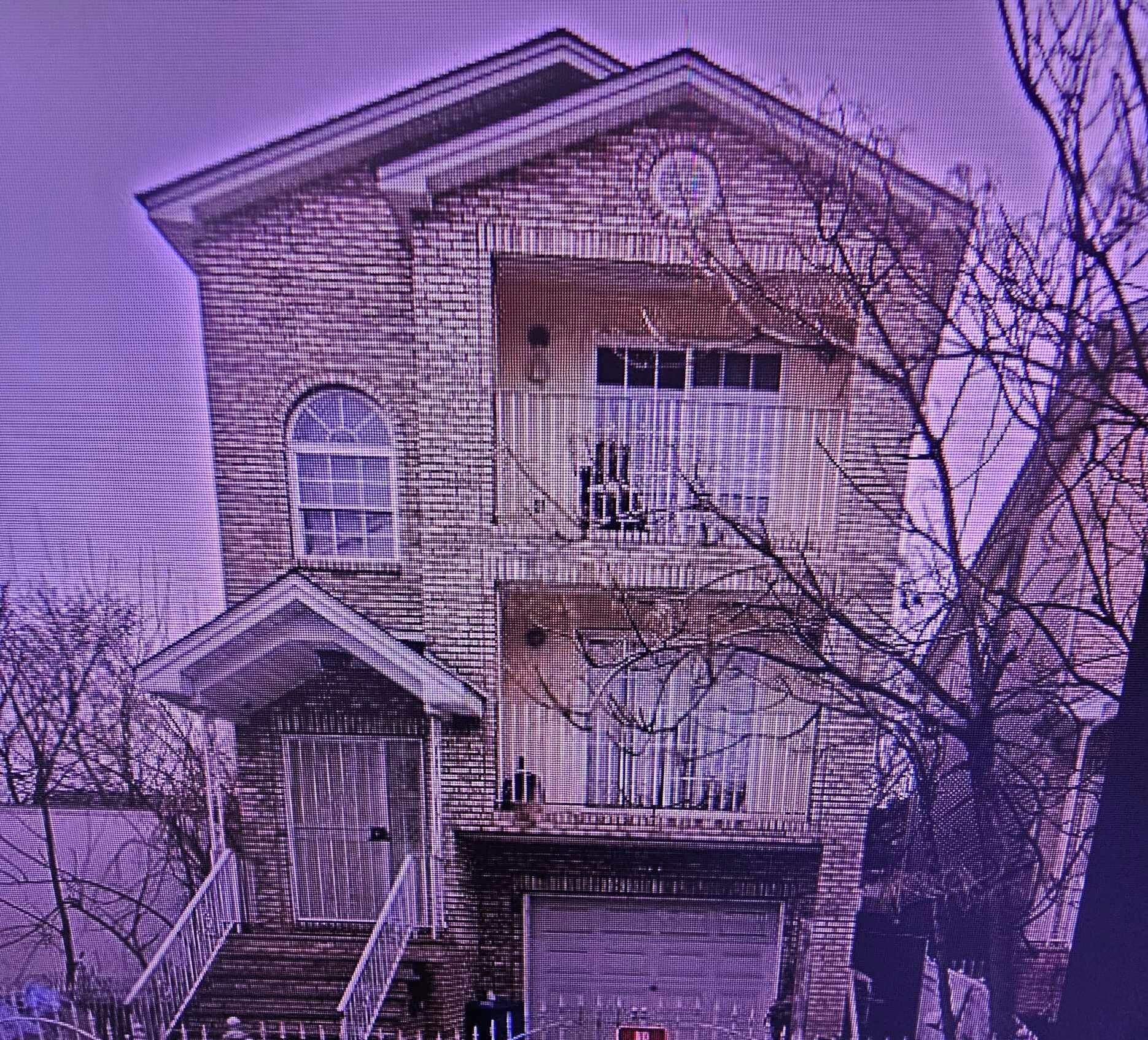 A two-story house with a front porch, a garage, and a "No Parking" sign.