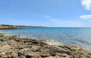 A rocky shoreline with clear blue water and a distant view of a coastal town. - 1 bedroom gorgeous home in Taviano (Taviano)