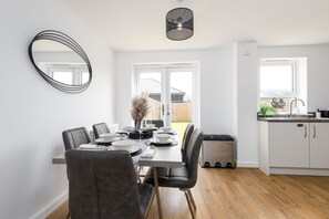 Enjoy meals in a spacious dining area with a rectangular table and matching chairs, illuminated by a pendant light.