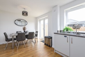 Enjoy meals in the kitchen and dining area, featuring a sink, stainless steel appliances, and a potted plant.
