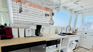 Una cocina moderna con lavavajillas, cafetera y hervidor sobre la encimera.