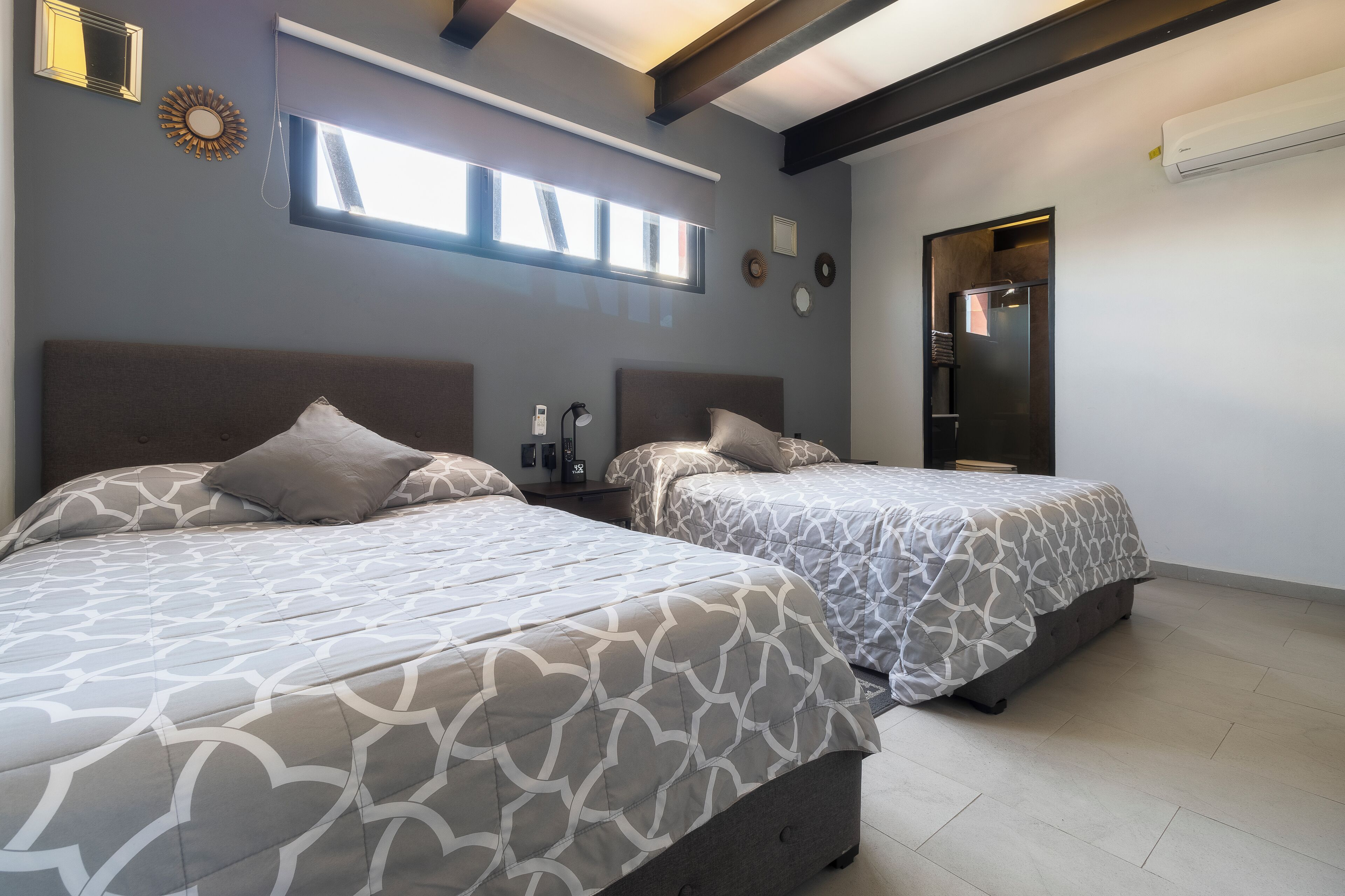 Een slaapkamer met twee bedden, een raam en een deur.
