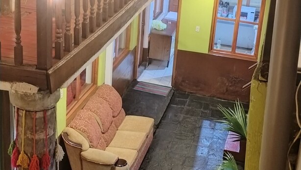 Eine mehrstufige Außenanlage mit einer Holztreppe, einer Couch und einem Blumentopf.