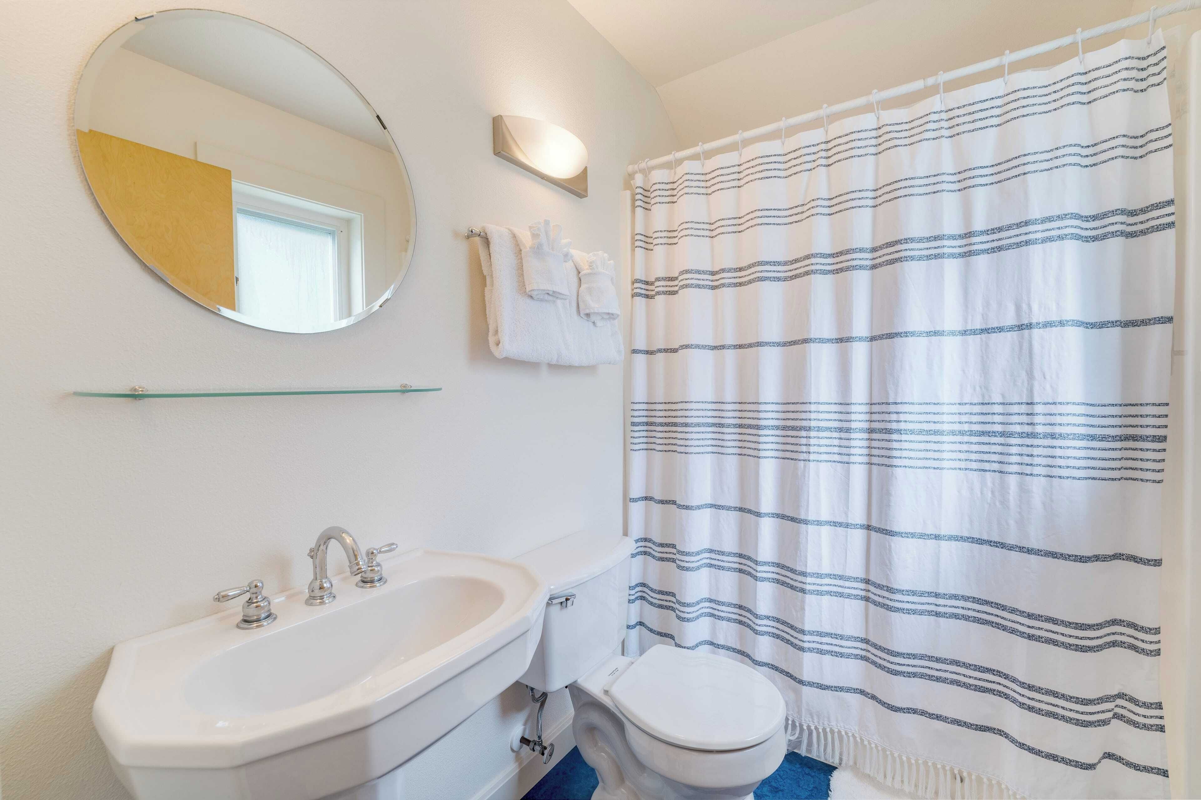 Une salle de bain avec un lavabo, des toilettes et un rideau de douche.