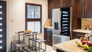 A modern kitchen with dark wood cabinets, stainless steel appliances, and a window with blinds. - Red River by Avantstay Shared Pool + Hot Tub 20 Minutes to Downtown Austin (Austin)