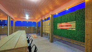 An indoor space with a wooden table, chairs, a green wall, and a sign reading 'Surf-n-Dipity.'