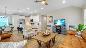 A modern living room with a wooden coffee table, a sofa, and a TV on a stand.